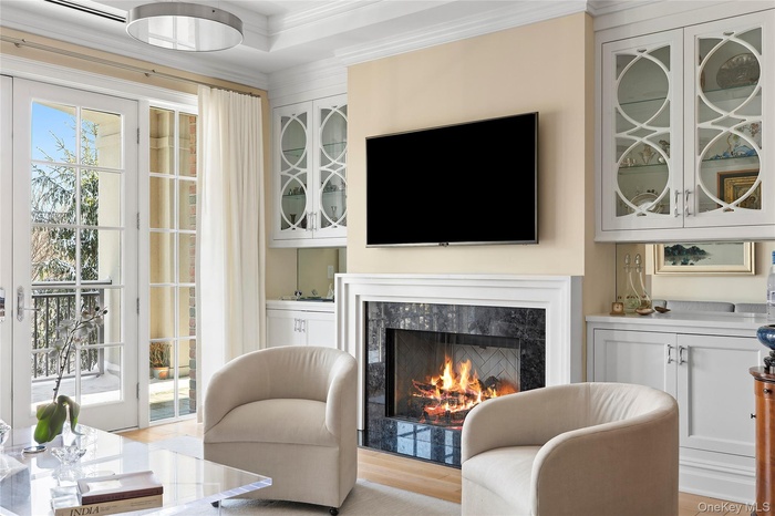 Sitting room with crown molding, a fireplace, and light hardwood / wood-style floors