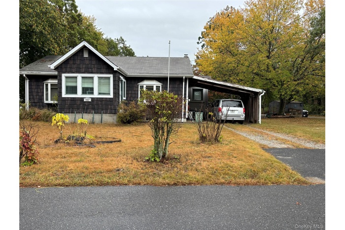 Ranch-style house featuring asphalt driveway and a front yard