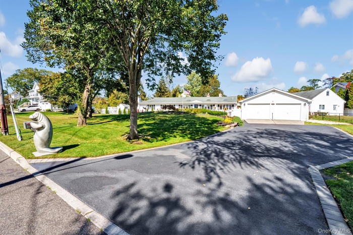 Single story home with a front yard, a residential view, and a detached garage
