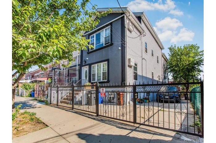 View of front of house featuring a fenced front yard, stucco siding, and a gate