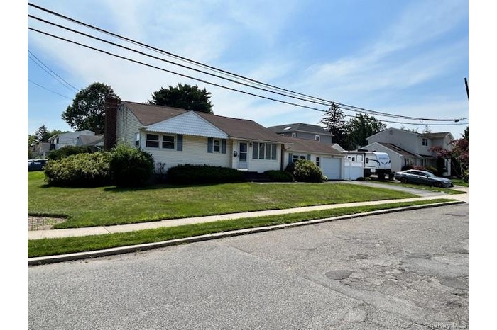 View of front of house featuring driveway, an attached garage, and a front yard