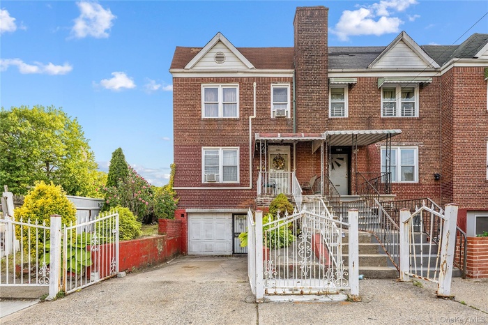 Townhome / multi-family property featuring an attached garage, concrete driveway, brick siding, and a chimney