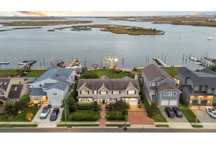 Aerial perspective of suburban area featuring a nearby body of water
