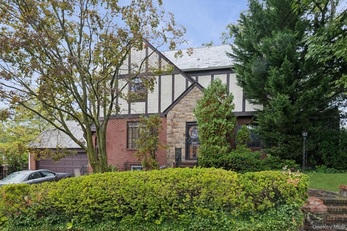 Tudor home featuring stucco siding and brick siding