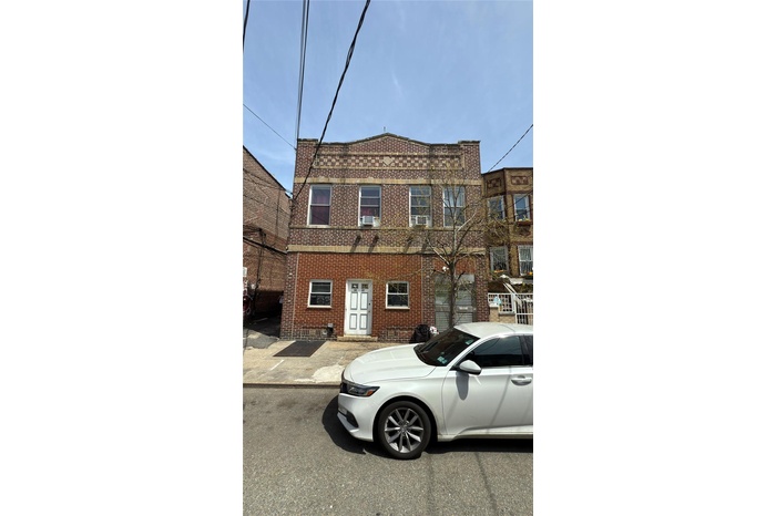 View of front of home featuring brick siding and cooling unit