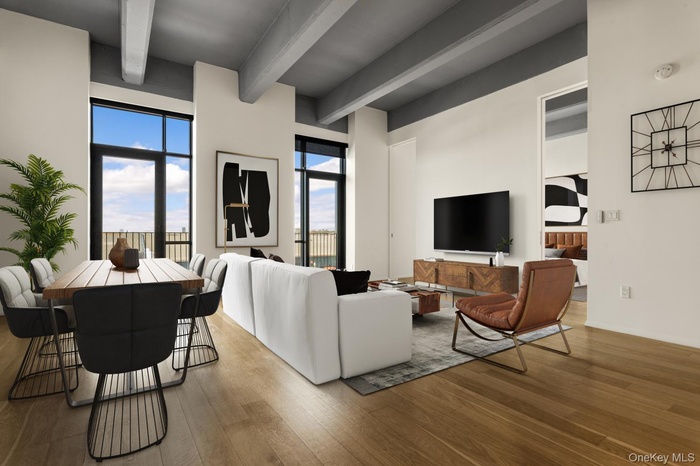 Living room featuring beam ceiling and wood finished floors
