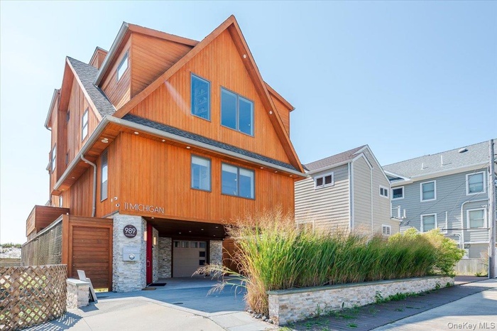 View of front of home with stone siding and a shingled roof
