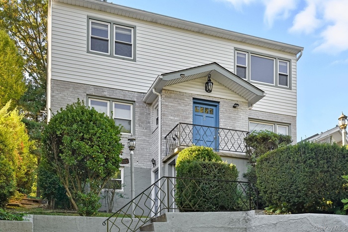 Traditional-style house featuring brick siding and stairs