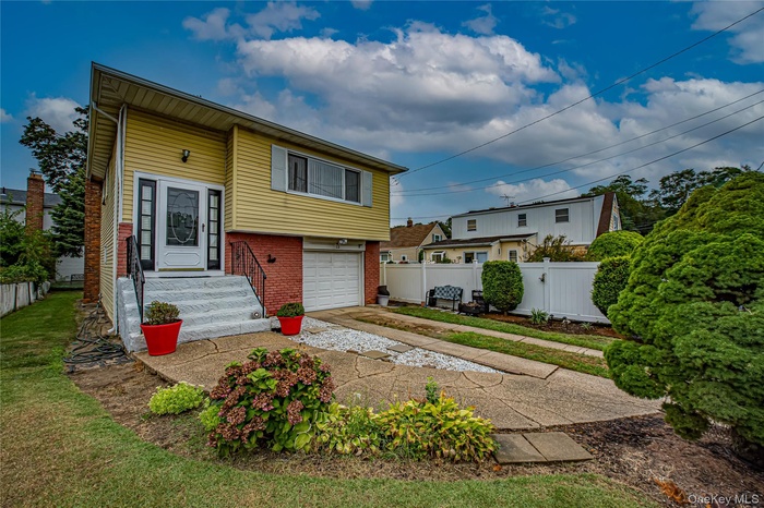 View of front of property with brick siding, driveway, and an attached garage