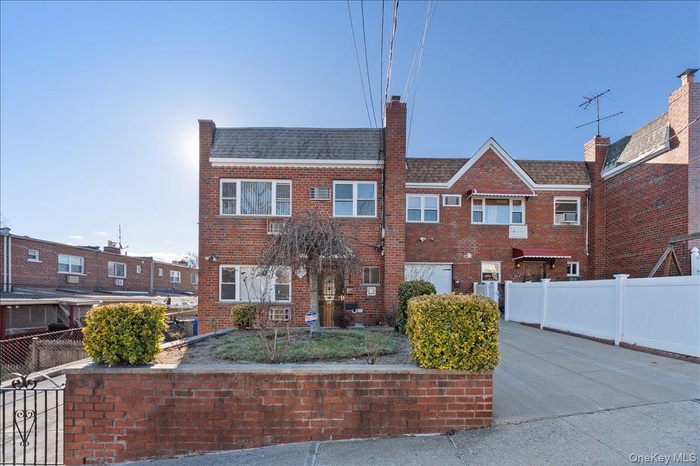 View of front of house featuring brick siding and a chimney