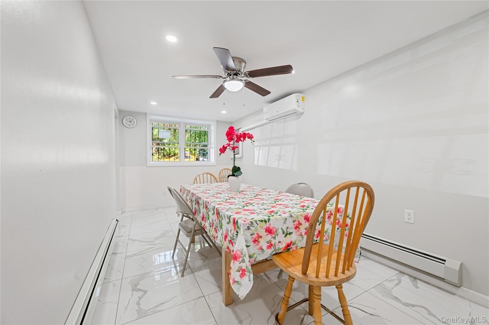 Dining room featuring a baseboard radiator, light marble finish flooring, recessed lighting, and ceiling fan