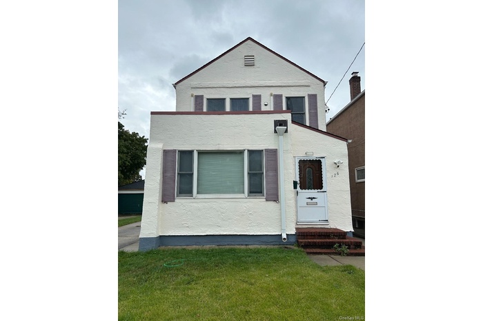 View of front of home featuring stucco siding, a front yard, and entry steps
