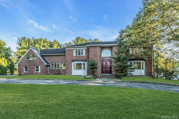 View of front of house with brick siding and a front yard