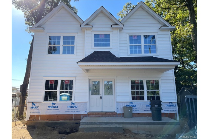 View of front of home with covered porch and stacked stone detail