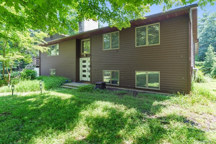 Rear view of house featuring a chimney
