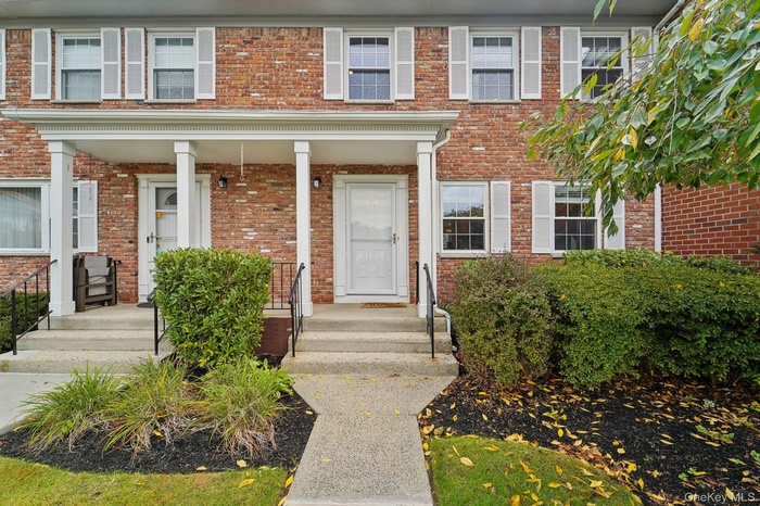 Entrance to property featuring brick siding and covered porch