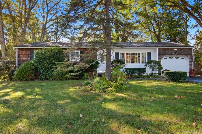 View of front of home with an attached garage and a front yard