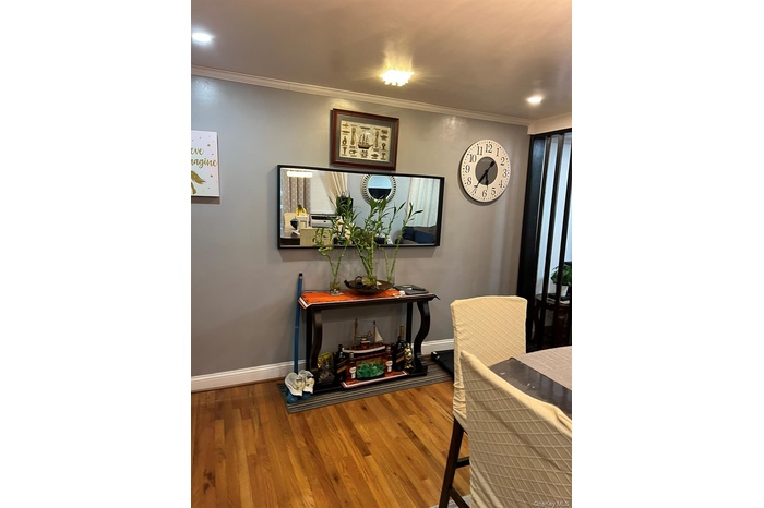 Dining area with ornamental molding, dark wood-style flooring, and recessed lighting