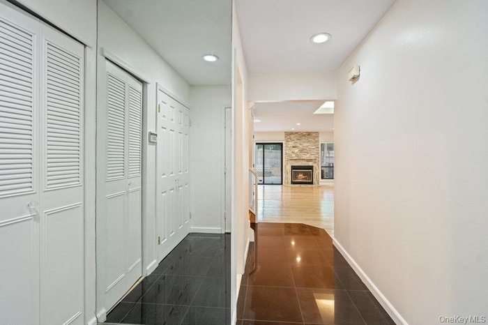 Corridor featuring recessed lighting and dark tile patterned floors