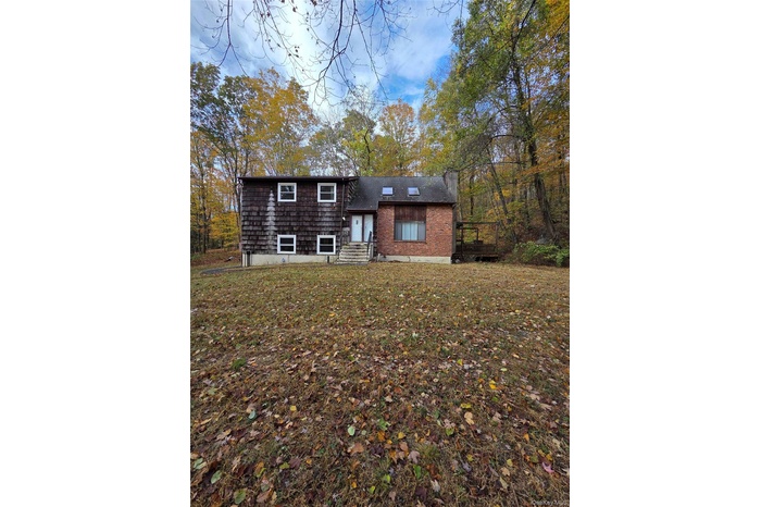 View of front facade featuring a front yard and brick siding