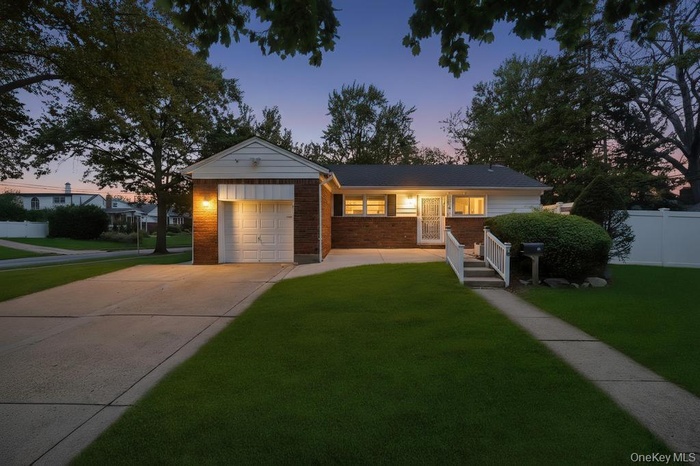 Ranch-style home featuring brick siding, driveway, and a garage