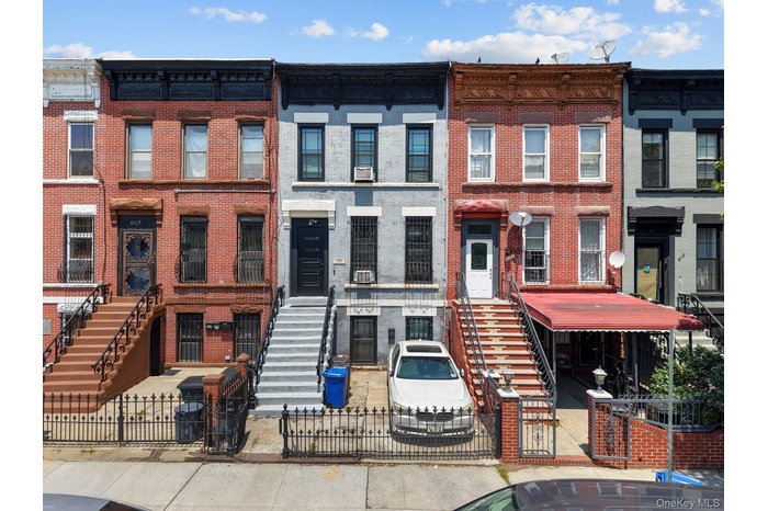 Italianate home with brick siding and a fenced front yard