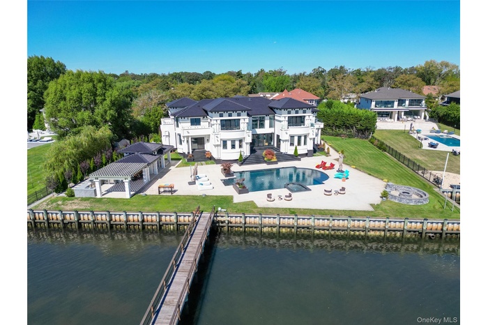 Back of property featuring a patio, a fenced backyard, a jacuzzi, and a water view