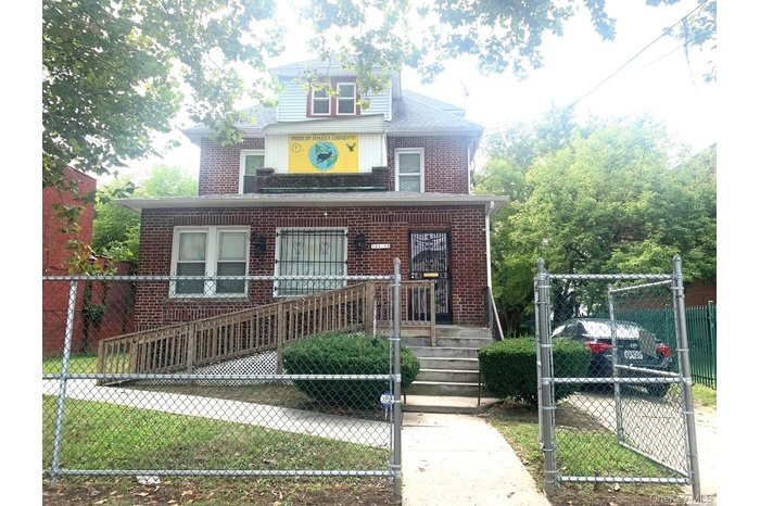 View of front of house featuring a gate, a fenced front yard, a porch, and brick siding