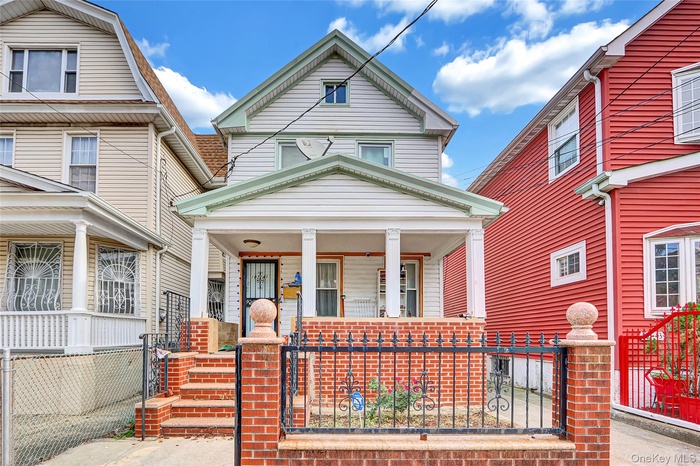View of front of home featuring covered porch and a fenced front yard