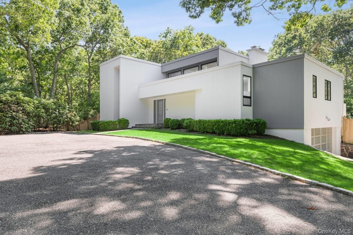 View of front of property featuring gravel driveway and a front lawn