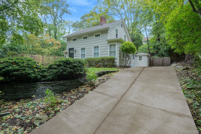 View of front facade featuring long driveway with ample parking