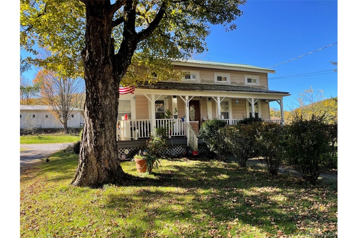 View of front facade featuring a front lawn and covered porch