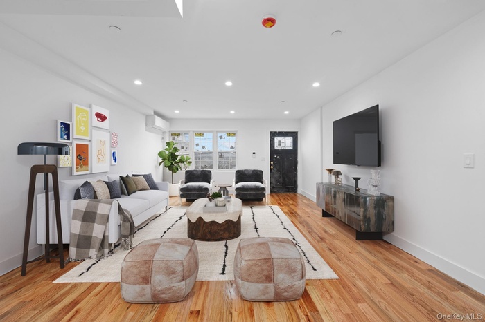 Living area featuring light wood finished floors and recessed lighting