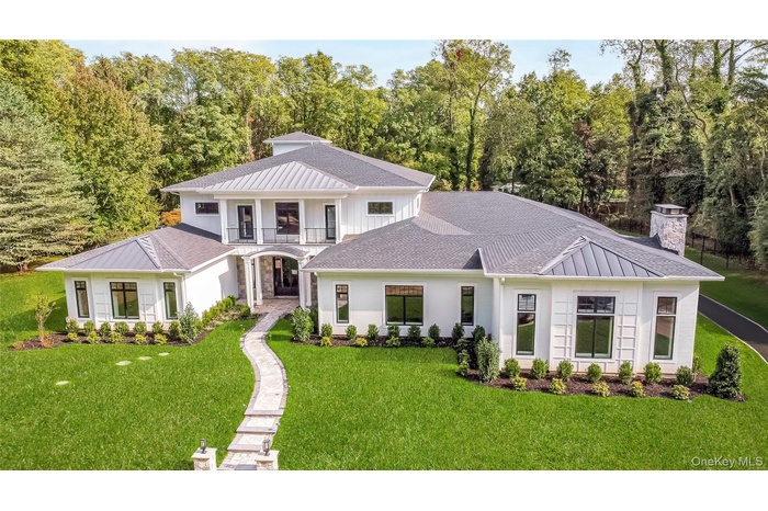 View of front of property featuring a standing seam roof, a chimney, a metal roof, and a shingled roof
