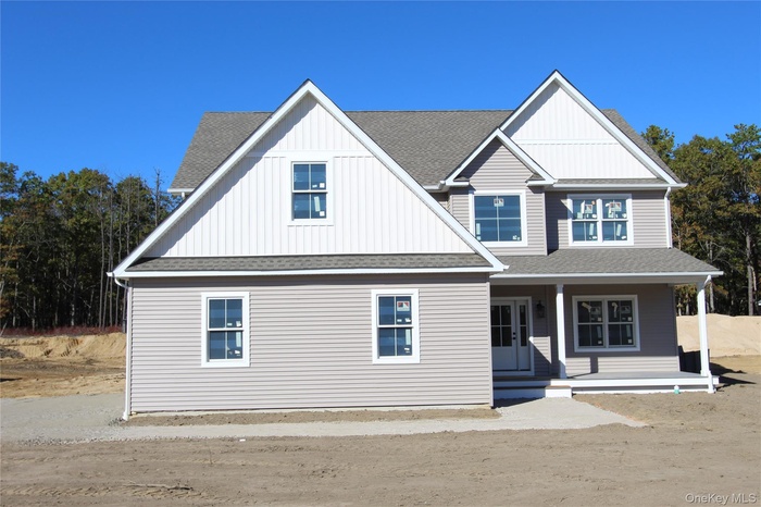 View of front of house with roof with shingles, covered porch, and board and batten siding