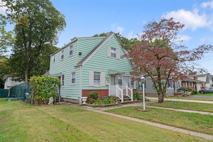 View of front facade featuring a front lawn and brick siding