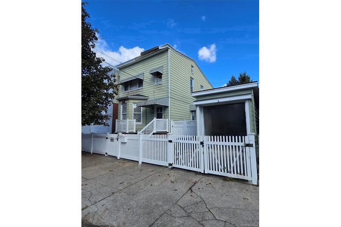 View of side of property featuring a gate and a fenced front yard