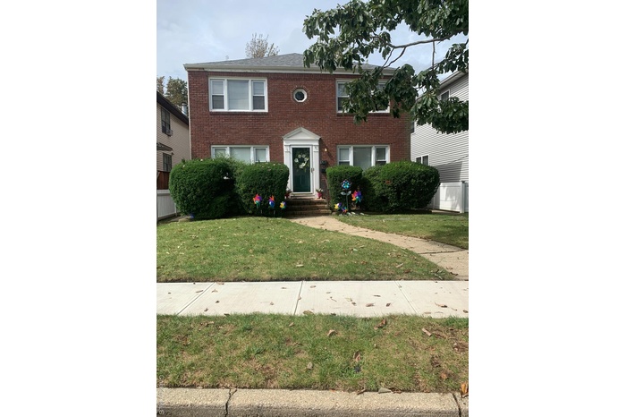 Colonial inspired home featuring brick siding and a front lawn