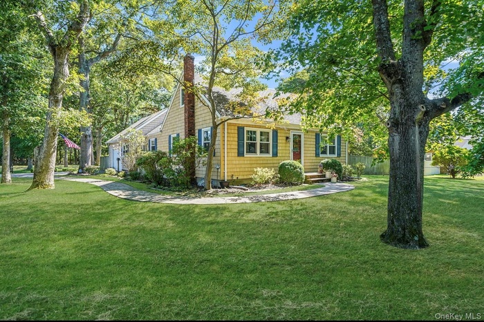 View of side of property with a lawn and a chimney