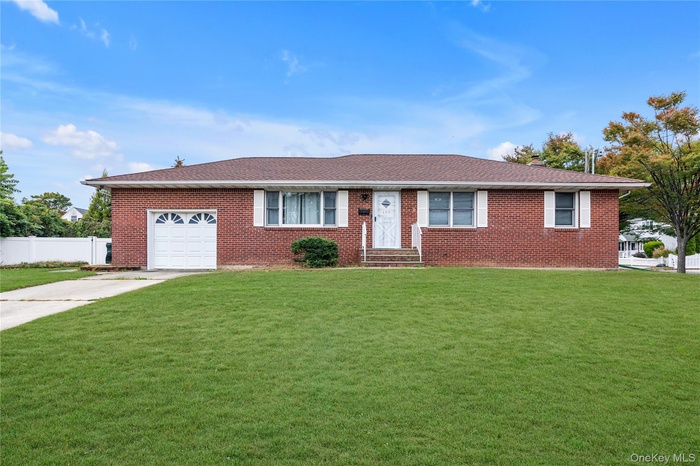 Single story home with brick siding, driveway, an attached garage, and roof with shingles