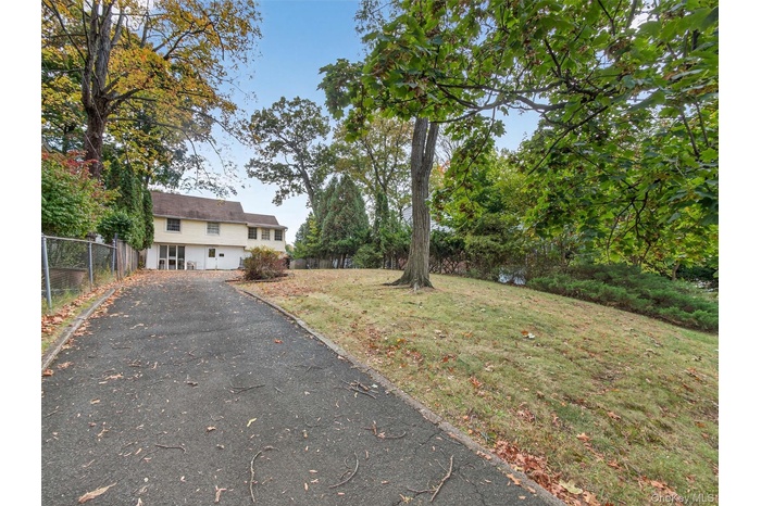 View of yard with asphalt driveway