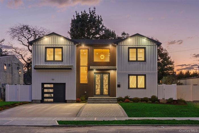 Modern farmhouse style home featuring concrete driveway, a gate, and french doors