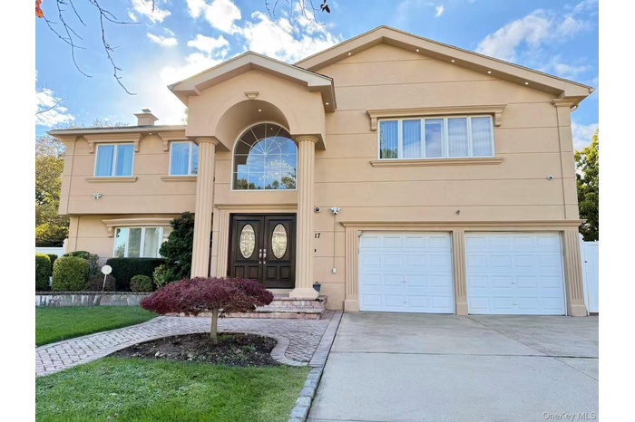 View of front of home with stucco siding, concrete driveway, an attached garage, and a chimney