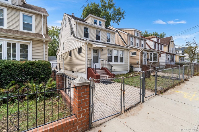 View of front of property featuring a gate, a fenced front yard, and a residential view