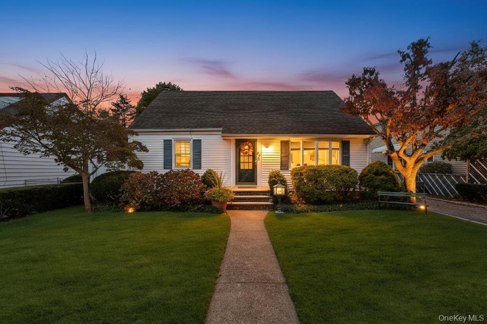 New england style home with a lawn and roof with shingles