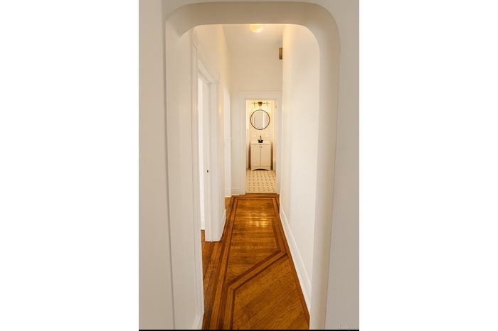 Corridor with arched walkways and wood finished floors
