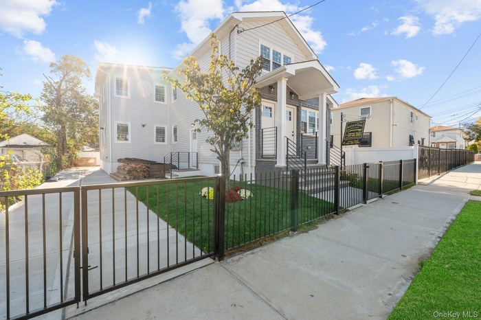 View of front facade with a fenced front yard and a gate