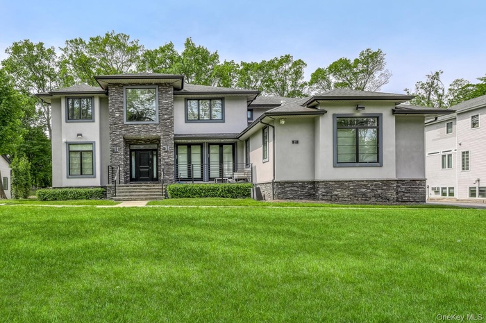 Prairie-style house with stone siding, stucco siding, and a front yard