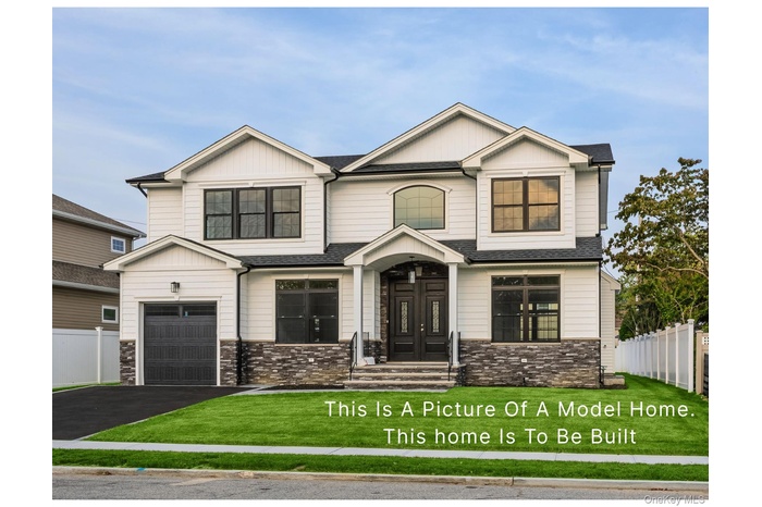 View of front facade with stone siding, driveway, roof with shingles, and board and batten siding