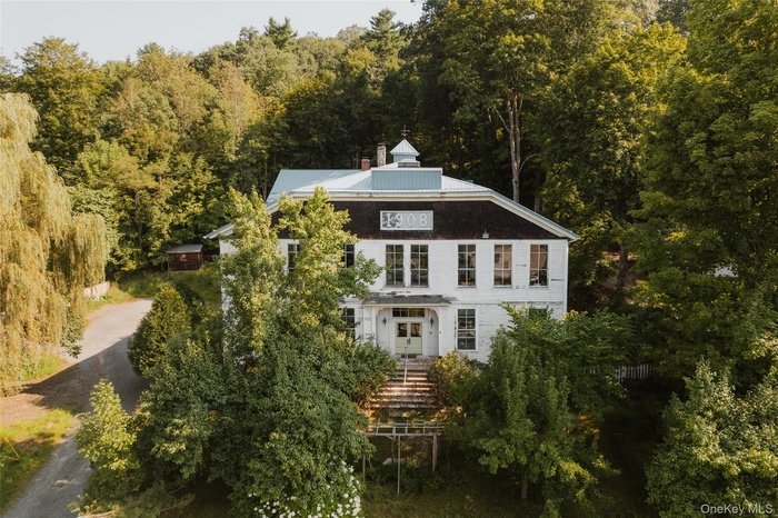 Back of property featuring a wooded view